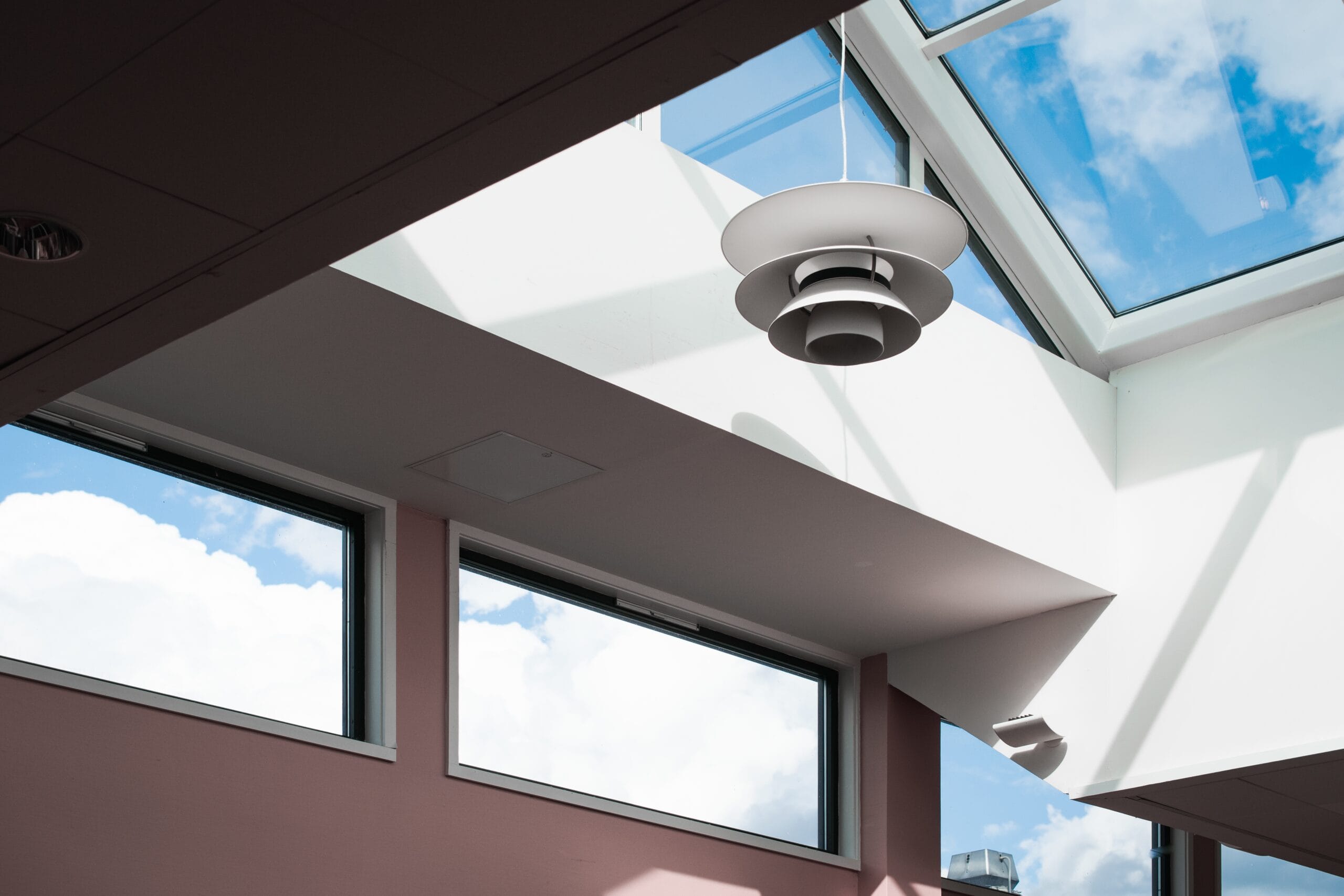 Low angle shot of a lamp hanging inside a building with a glass ceiling Inside of Conservatort