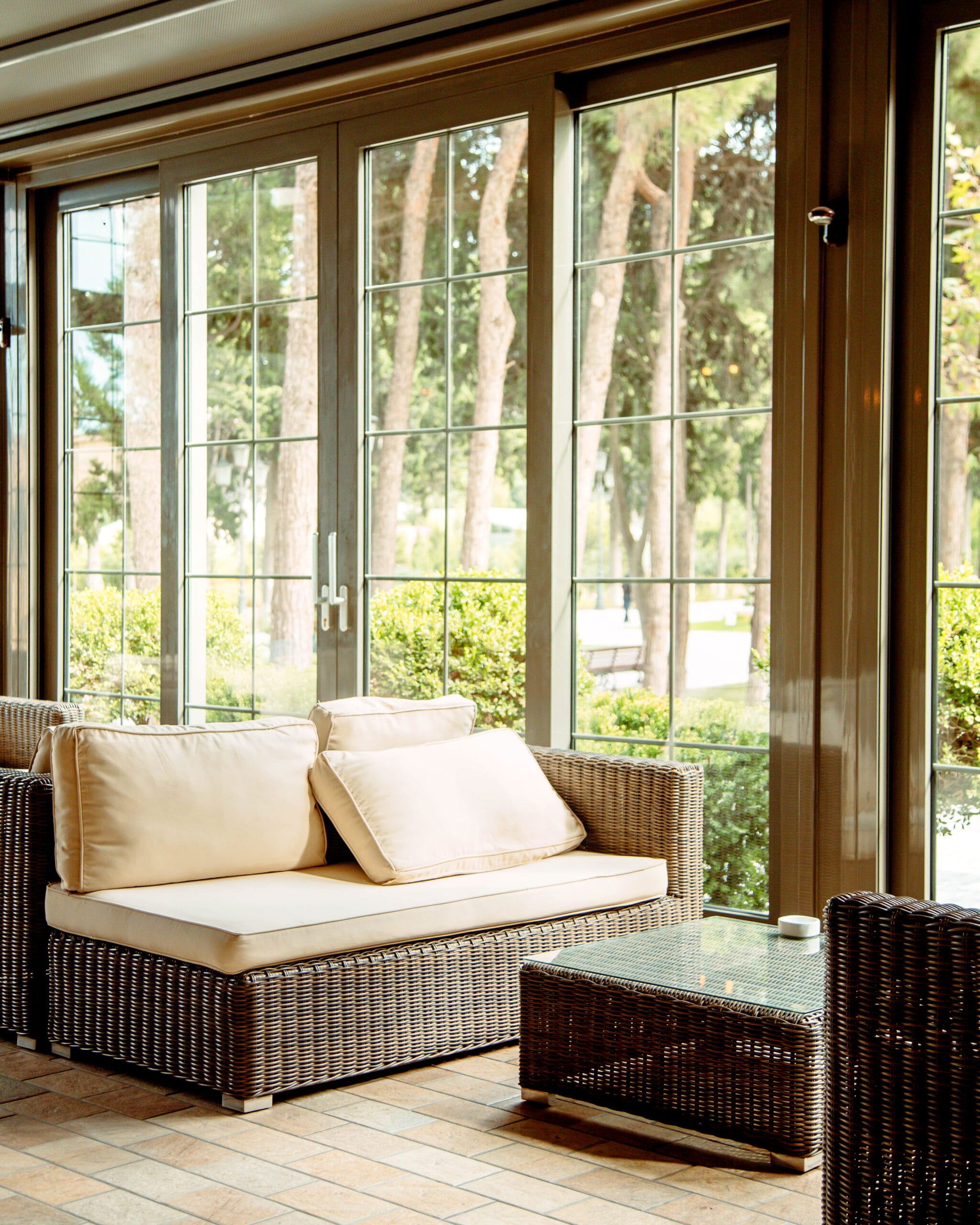 outdoor sofa with beige cushions and coffee table in front of the restaurant window Conservatory roof interior